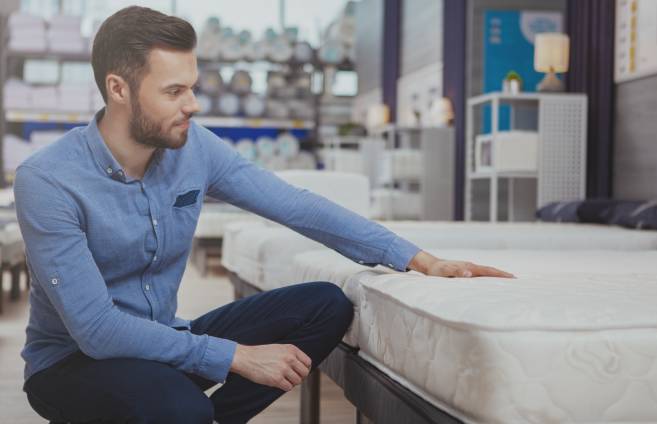 Homme qui regarde un matelas