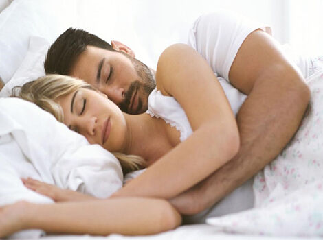 un homme et une femme qui dorment dans un lit