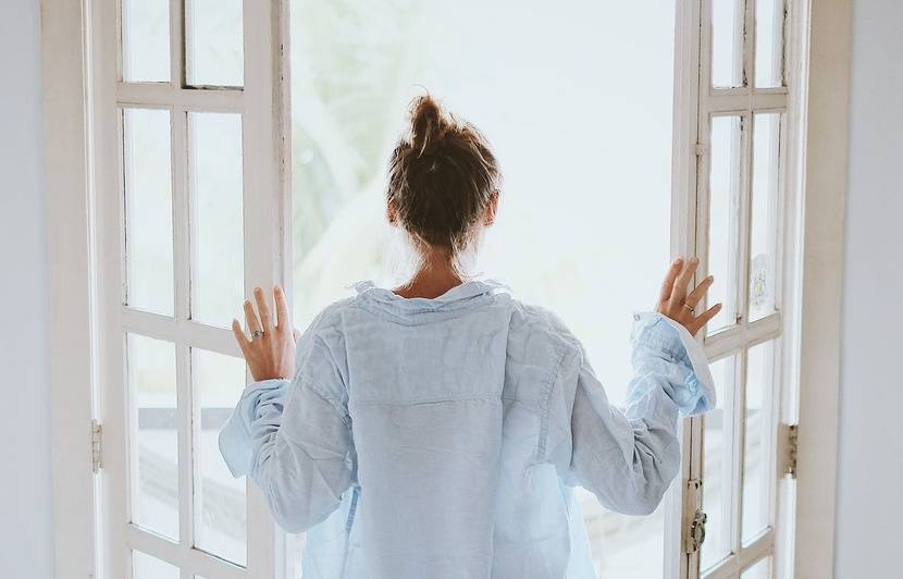 une femme qui ouvre une fenetre